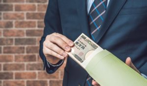 お金（大金）を持つスーツの男性